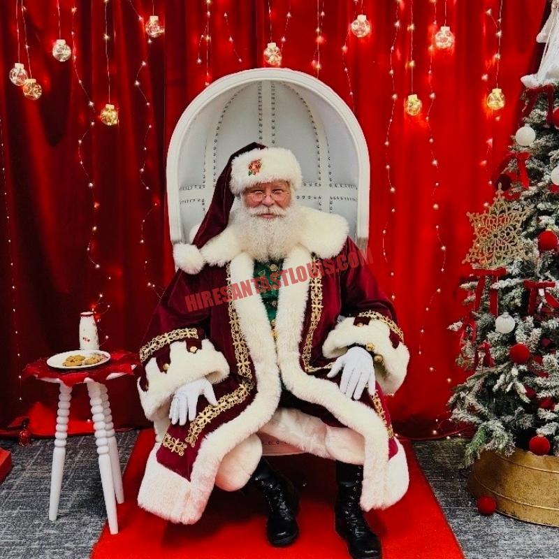 Santa for hire in Chesterfield, MO: real bearded Santa in a white chair with cookies and milk by a tree.