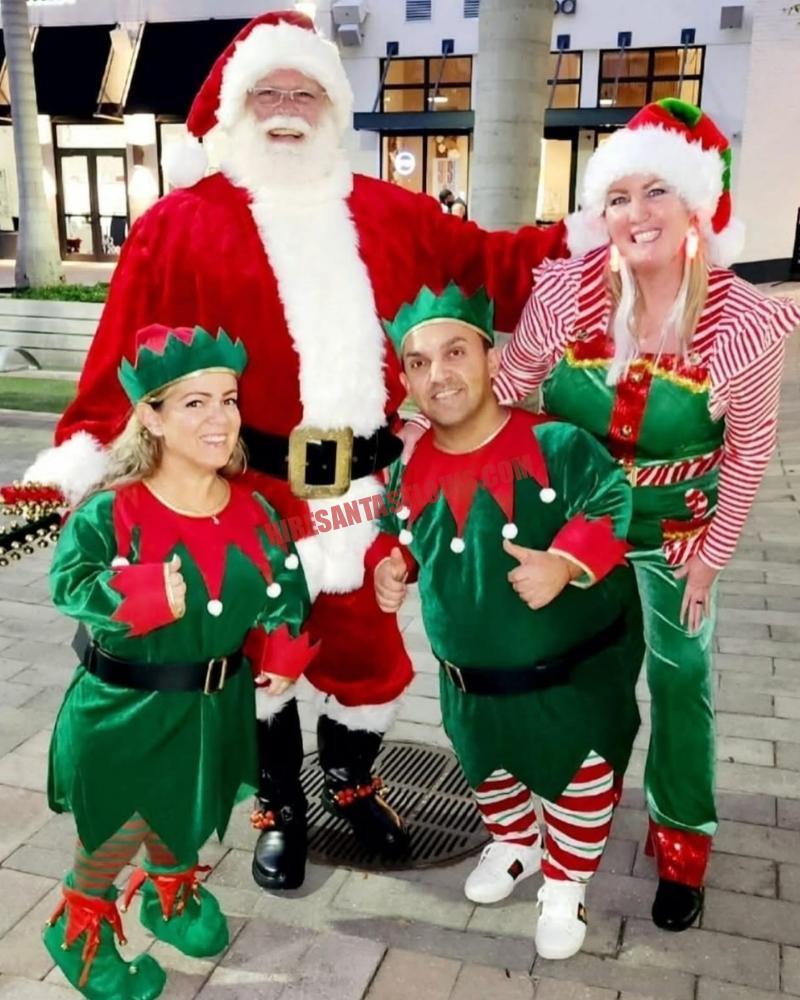 School Santa visit in St. Louis: Santa outdoors at dusk with three elves on pavers.