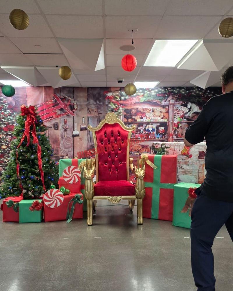 Santa photos in St. Louis: gold chair among gift boxes, a lit tree, and a workshop backdrop.